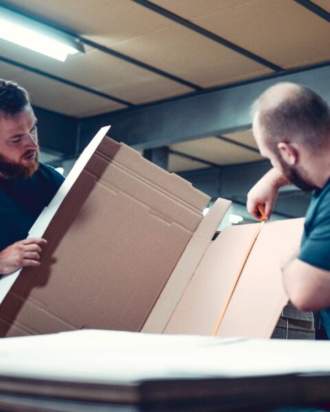 Medewerkers kartonnen verpakking aan het opmeten.