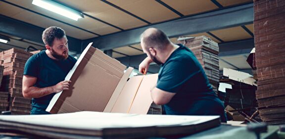 Medewerkers kartonnen verpakking aan het opmeten.